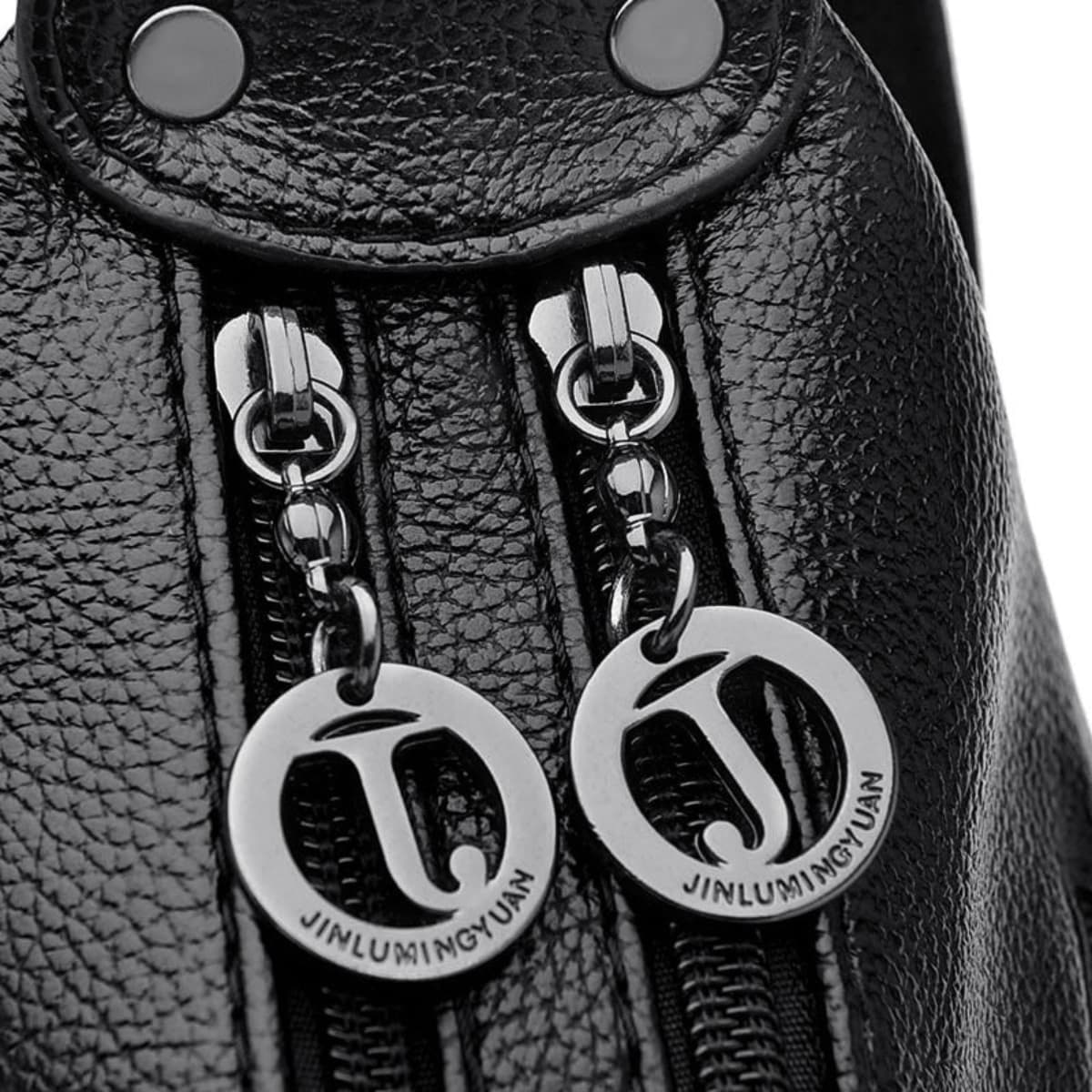 Close up of black leather bag with dual zipper pulls and silver hardware detail