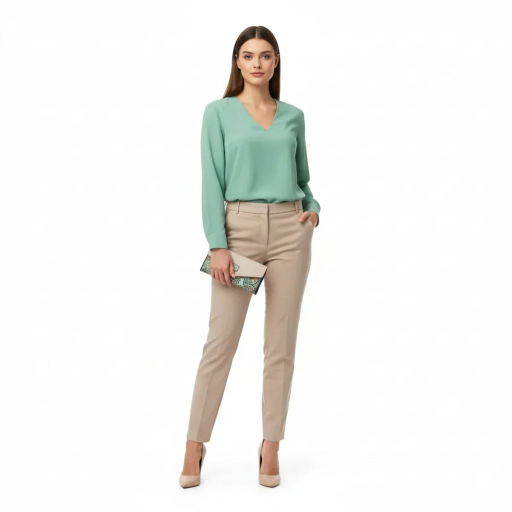 Frau mit beiger Hose, mintgrüner Bluse und Geldbörse Damen beige-mint mit Vogel und Blumenmotiv