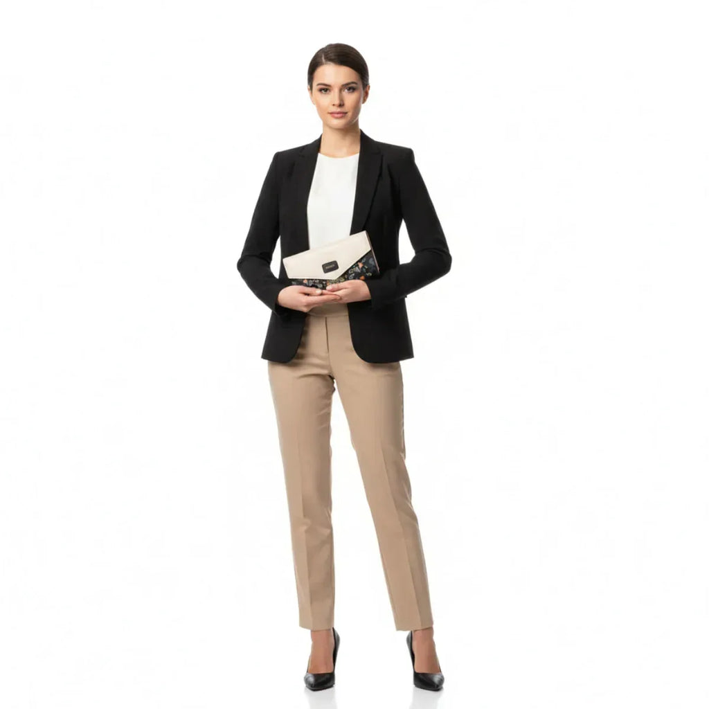 Dame im Business-Outfit hält beige-schwarze Geldbörse mit Vogel- und Blumenmotiv.