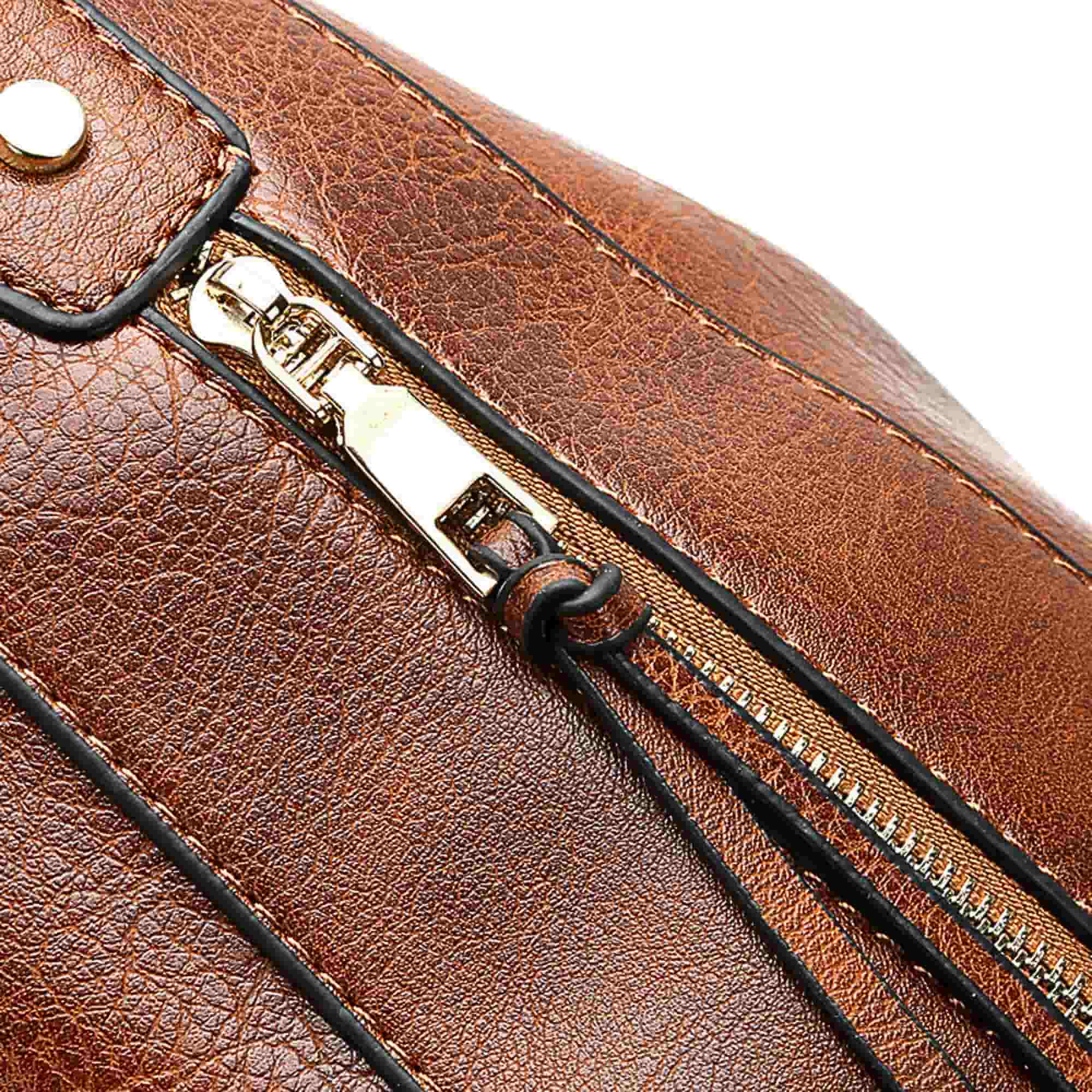 Close-up of gold zipper and stitching detail on brown leather hobo bag