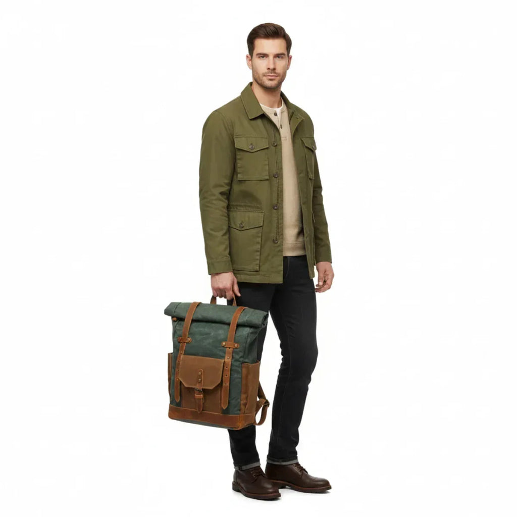 Mann mit grünem Canvas-Leder Rucksack im Retro-Stil, in der Hand haltend
